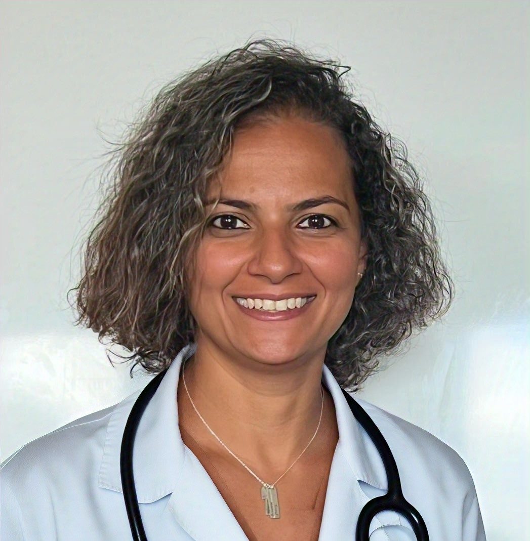 Dr. Nancy Zaghloul Dr. Nancy Zaghloul, a veterinarian, smiles warmly while wearing a white lab coat and a stethoscope around her neck. She stands in front of a light-colored background, creating a clean and professional portrait.